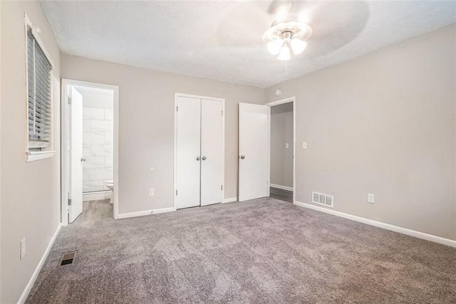 4442 Cedar Ridge Trl, Stone Mountain, GA 30083 - unfurnished bedroom with carpet flooring, connected bathroom, a textured ceiling, a closet, and a ceiling fan