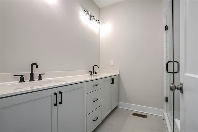 bathroom featuring a shower with door, vanity, and tile patterned flooring