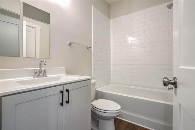 full bathroom featuring tiled shower / bath combo, vanity, hardwood / wood-style flooring, and toilet