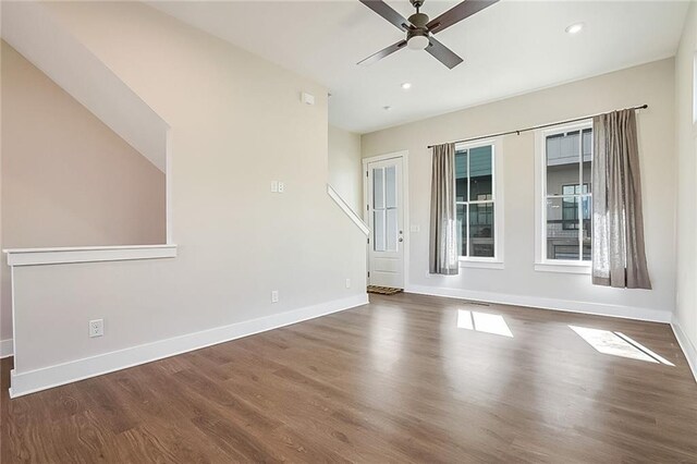 unfurnished living room with ceiling fan with notable chandelier, dark hardwood / wood-style floors, and sink