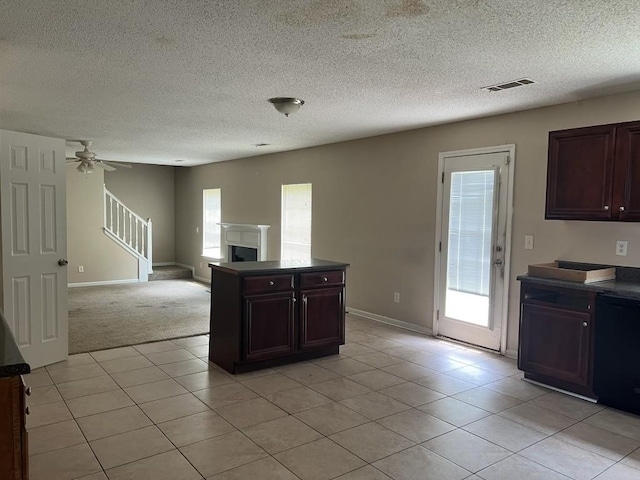 6157 Redtop Loop, Fairburn, GA 30213 - kitchen with light tile patterned floors, a fireplace, open floor plan, a ceiling fan, and a textured ceiling