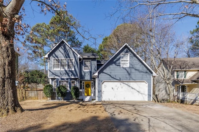 view of front of house with a garage, concrete driveway, and fence