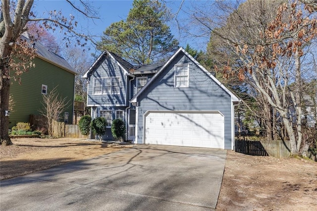 view of front facade with a garage, concrete driveway, and fence