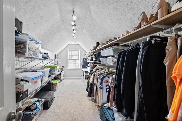 walk in closet featuring carpet floors and vaulted ceiling