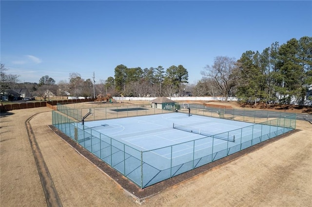 view of tennis court with community basketball court and fence