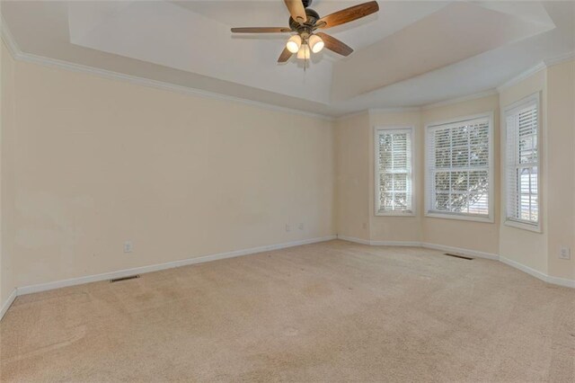 189 Meadow Spring Dr, Temple, GA 30179 - empty room with a raised ceiling, light colored carpet, ceiling fan, crown molding, and baseboards
