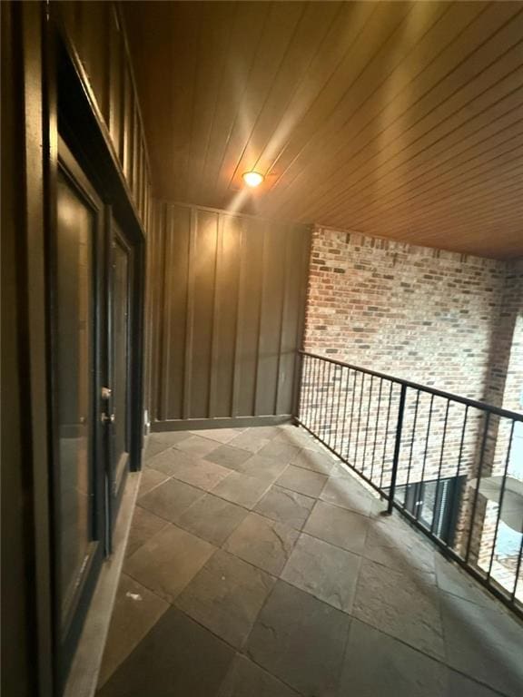 interior space featuring brick wall and wooden ceiling