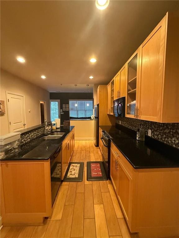 kitchen with backsplash, sink, light hardwood / wood-style flooring, and black appliances