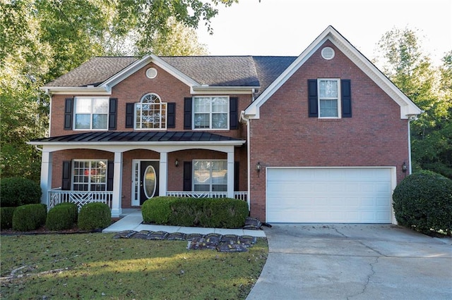 view of front of home featuring a garage, a front lawn, and covered porch