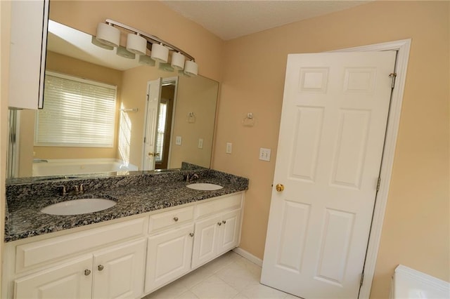 994 Rolling Forest Ln, Lilburn, GA 30047 - bathroom featuring a garden tub, tile patterned floors, double vanity, and baseboards