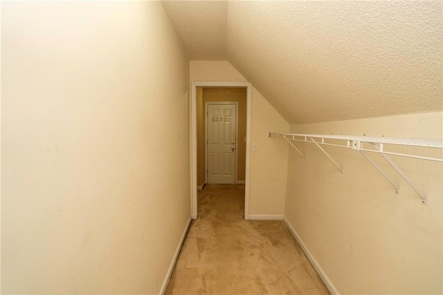 spacious closet featuring lofted ceiling and light carpet