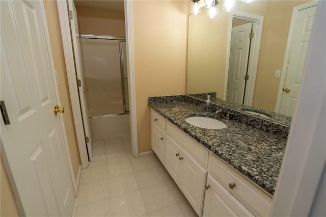 bathroom featuring tile patterned flooring, vanity, and enclosed tub / shower combo