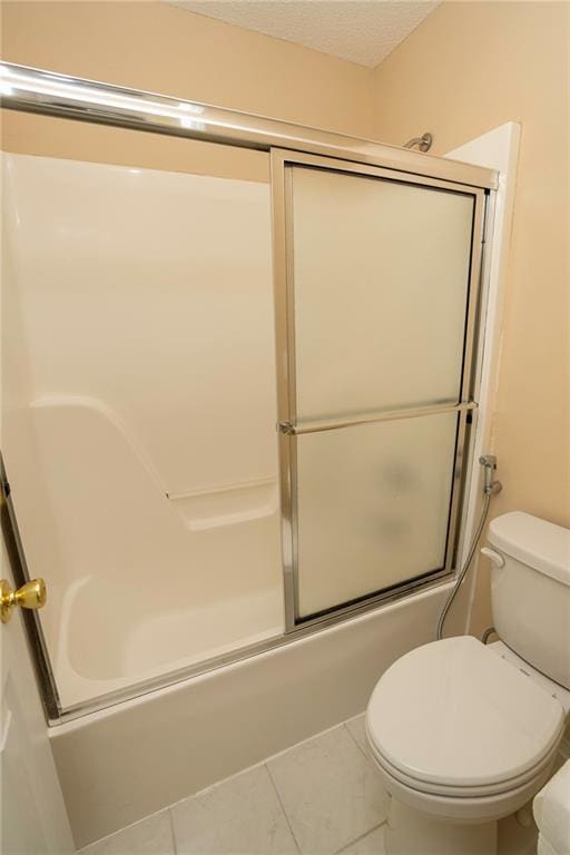 bathroom with tile patterned floors, bath / shower combo with glass door, and toilet