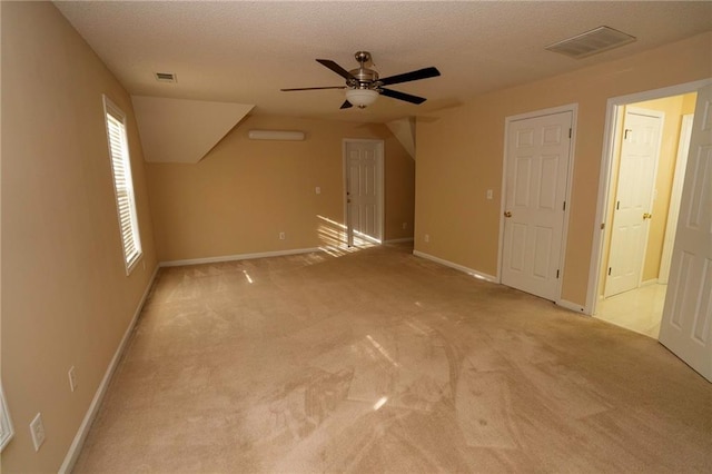 bonus room featuring ceiling fan, light colored carpet, and a textured ceiling