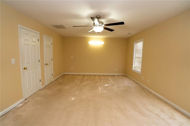 unfurnished bedroom with ceiling fan, two closets, and carpet flooring