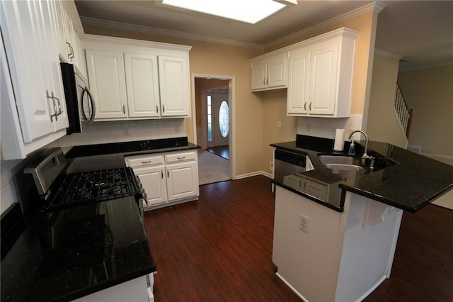 994 Rolling Forest Ln, Lilburn, GA 30047 - kitchen featuring a sink, appliances with stainless steel finishes, a peninsula, decorative backsplash, and dark wood-type flooring