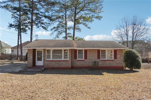 view of front of home featuring brick siding and a front lawn