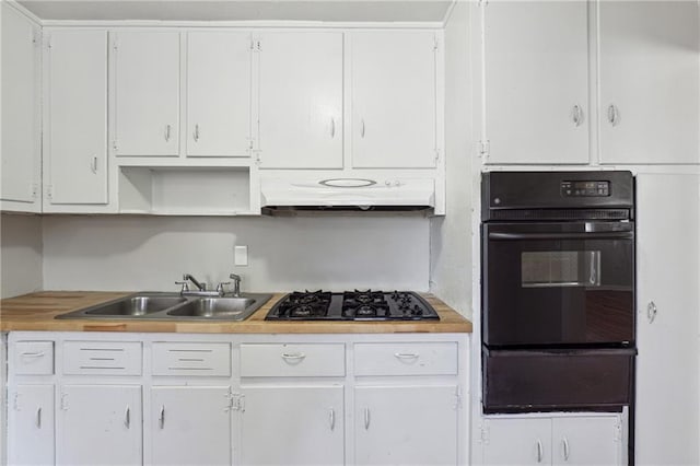 kitchen featuring black gas cooktop, a sink, under cabinet range hood, a warming drawer, and white cabinetry