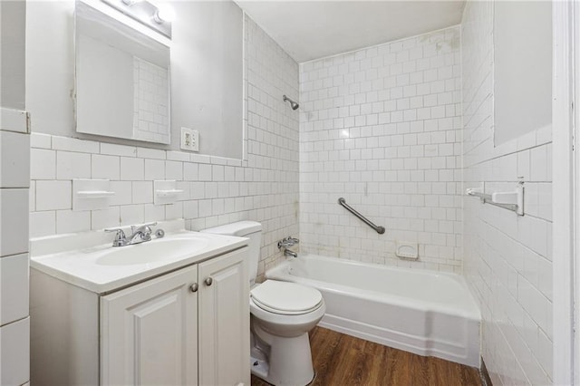 full bath featuring toilet, tile walls, vanity, wood finished floors, and bathing tub / shower combination