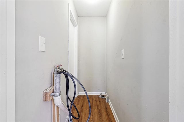hall with baseboards and wood finished floors