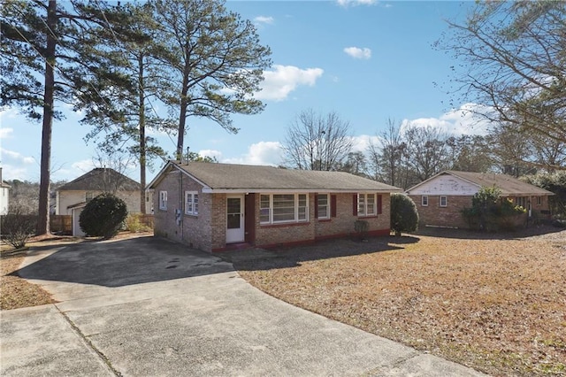 single story home with concrete driveway and brick siding