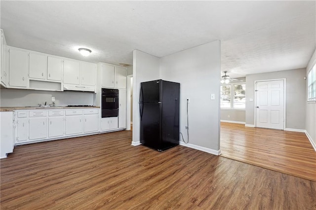 kitchen with baseboards, a ceiling fan, white cabinets, black appliances, and wood finished floors