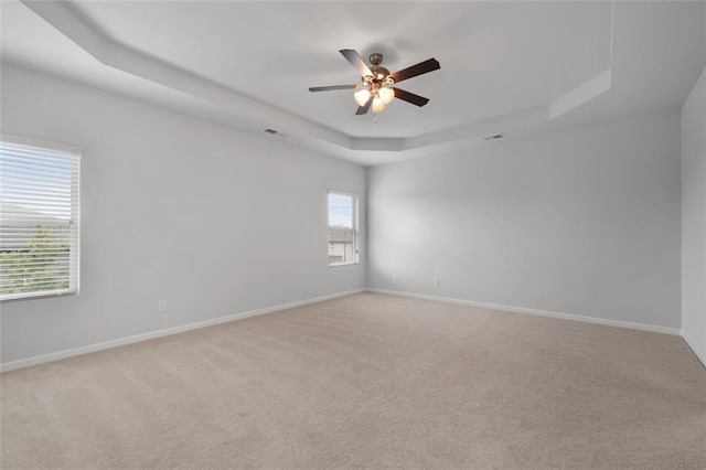 2537 Sori Dr, Buford, GA 30519 - spare room featuring a tray ceiling, light carpet, a ceiling fan, and baseboards