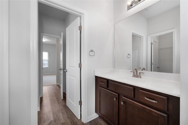 2537 Sori Dr, Buford, GA 30519 - bathroom featuring vanity, wood finished floors, baseboards, and a spacious closet