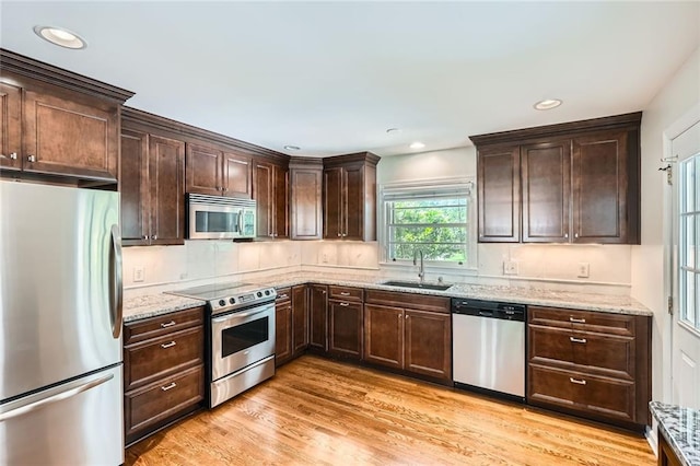 739 Pinehill Dr SE, Smyrna, GA 30080 - kitchen featuring appliances with stainless steel finishes, dark brown cabinets, light stone counters, light wood-style flooring, and recessed lighting