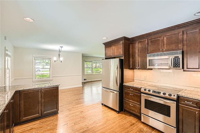 739 Pinehill Dr SE, Smyrna, GA 30080 - kitchen featuring stainless steel appliances, dark brown cabinetry, light wood finished floors, light stone countertops, and recessed lighting