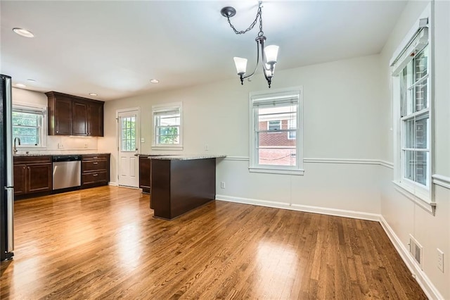 739 Pinehill Dr SE, Smyrna, GA 30080 - kitchen with stainless steel dishwasher, dark brown cabinets, a chandelier, wood finished floors, and hanging light fixtures