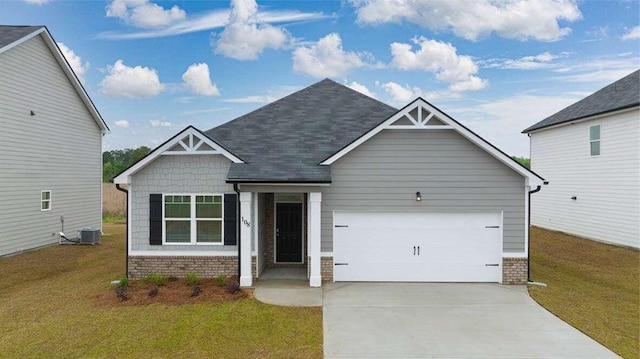 craftsman-style home featuring cooling unit, a front yard, and a garage