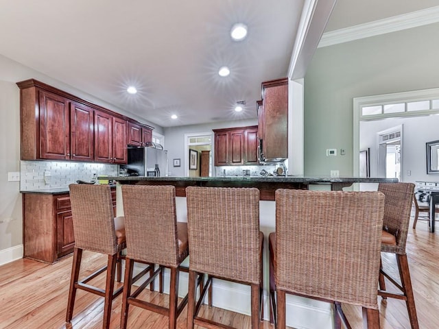1076 Pinyan Ln, Canton, GA 30115 - kitchen with stainless steel refrigerator with ice dispenser, dark countertops, light wood-style floors, tasteful backsplash, and crown molding