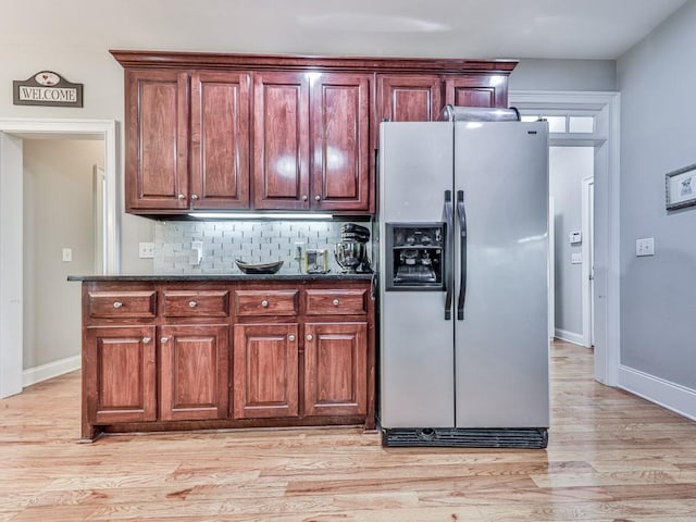 1076 Pinyan Ln, Canton, GA 30115 - kitchen with stainless steel fridge with ice dispenser, backsplash, light wood-type flooring, and dark stone counters