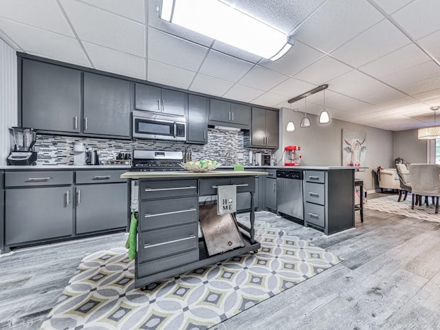 1076 Pinyan Ln, Canton, GA 30115 - kitchen with appliances with stainless steel finishes, light wood-type flooring, backsplash, gray cabinets, and a peninsula