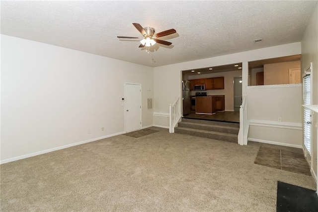 137 Legend Creek Dr, Canton, GA 30114 - unfurnished living room featuring carpet, a textured ceiling, a ceiling fan, stairs, and baseboards