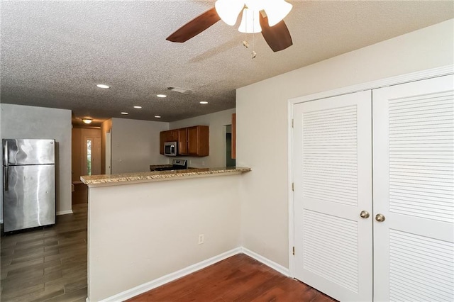 137 Legend Creek Dr, Canton, GA 30114 - kitchen featuring appliances with stainless steel finishes, dark wood-style flooring, a ceiling fan, brown cabinetry, and recessed lighting