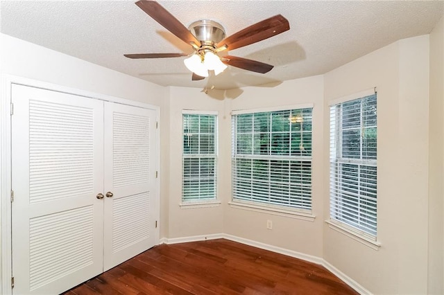 137 Legend Creek Dr, Canton, GA 30114 - unfurnished bedroom featuring dark wood-style flooring, baseboards, a closet, a textured ceiling, and multiple windows
