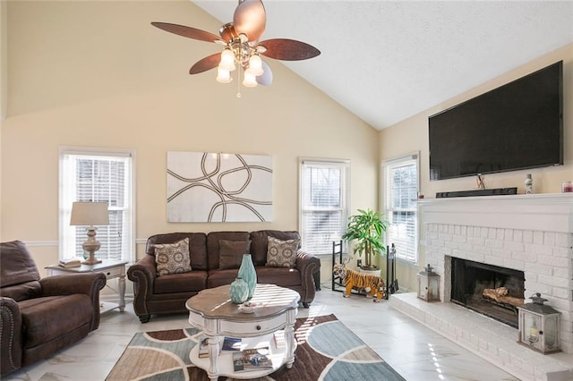 living room with a textured ceiling, high vaulted ceiling, a fireplace, and ceiling fan