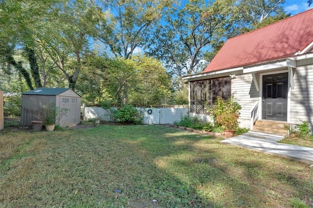 view of yard with entry steps, an outbuilding, a storage unit, and fence