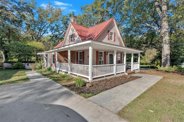 view of home's exterior featuring a lawn, covered porch, and a chimney