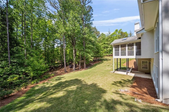 view of yard featuring a sunroom and a patio
