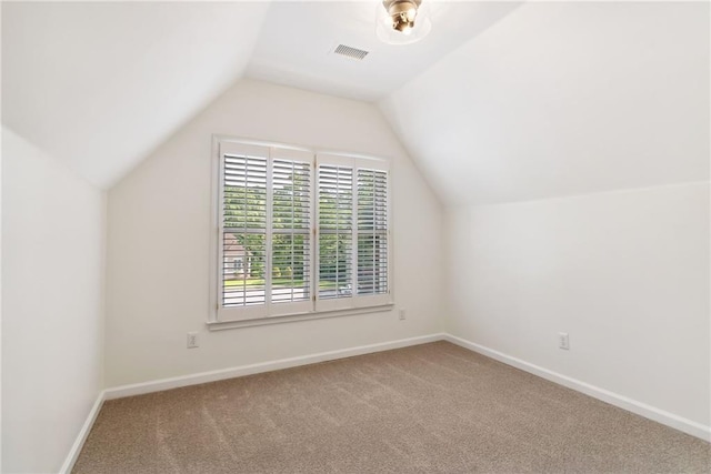 additional living space with baseboards, carpet, lofted ceiling, and visible vents