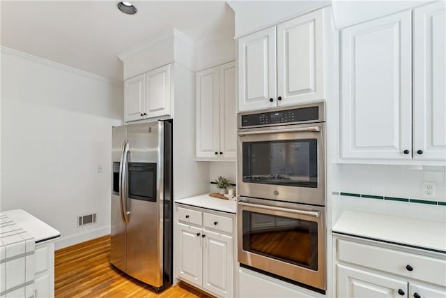 kitchen featuring visible vents, appliances with stainless steel finishes, backsplash, and white cabinets
