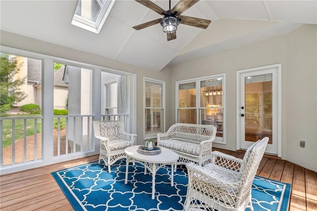 sunroom featuring vaulted ceiling with skylight and wood-type flooring