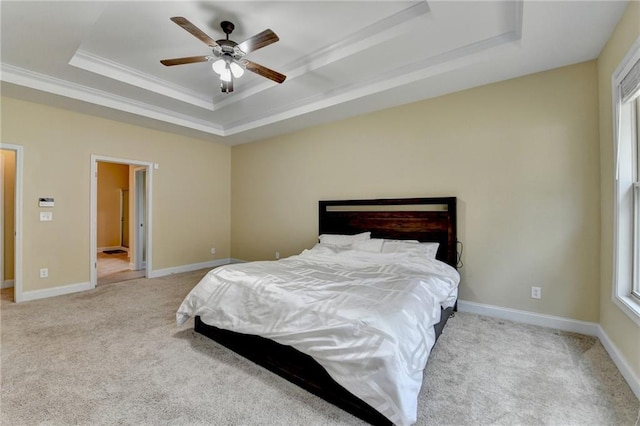 carpeted bedroom featuring a raised ceiling, ornamental molding, and ceiling fan