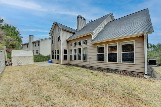 rear view of house with a yard, central AC unit, and a patio area