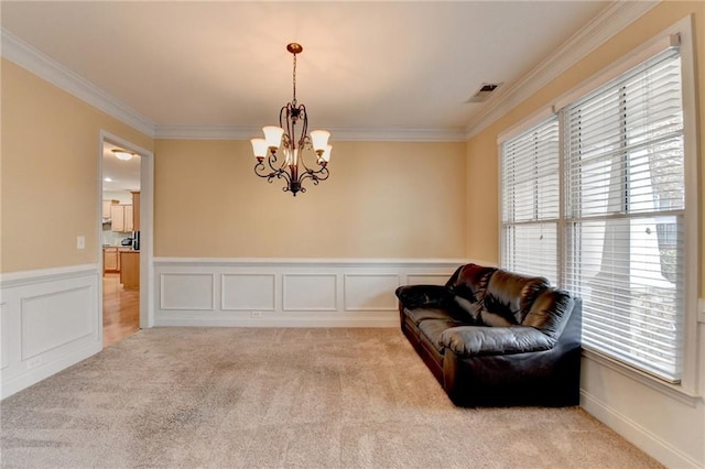 sitting room featuring light colored carpet, ornamental molding, and a chandelier