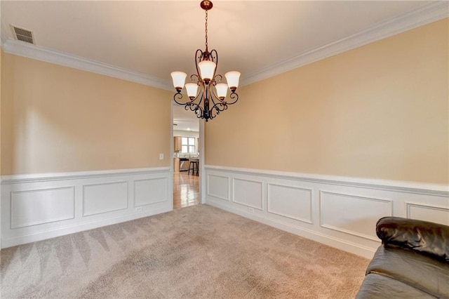 unfurnished room with an inviting chandelier, light colored carpet, and ornamental molding