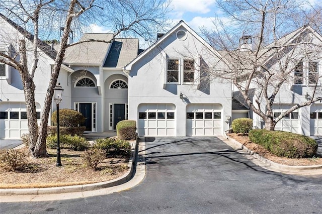 view of front of house with driveway, an attached garage, and stucco siding